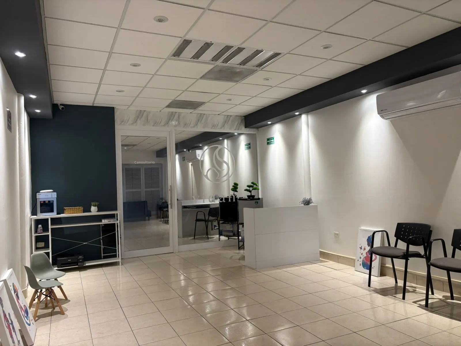 Recepción y sala de espera del consultorio, luminosa y ordenada